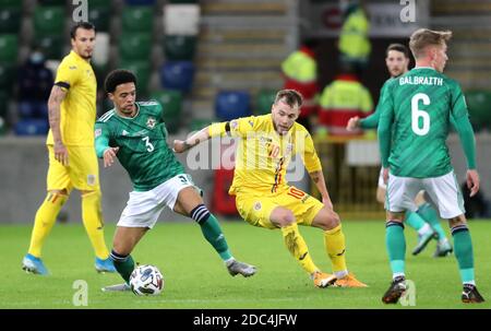 Northern Ireland's Jamal Lewis (left) and Romania's Alexandru Maxim battle for the ball during the UEFA Nations League match at Windsor Park, Belfast. Stock Photo