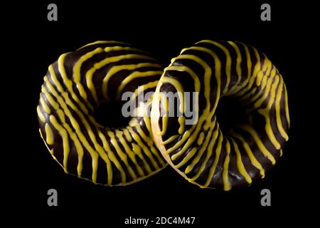 Two American donuts covered with shekolade on a black background Stock Photo