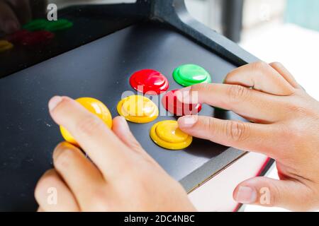 close-up hands pressing and holding joystick of old arcade video game Stock Photo