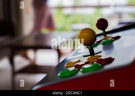 silhouette yellow joystick and six colorful button of an old arcade video game on blur background Stock Photo