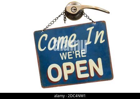 old rusty metal plate with word Come In We're Open haning on a knob and door handle isolated on white background Stock Photo