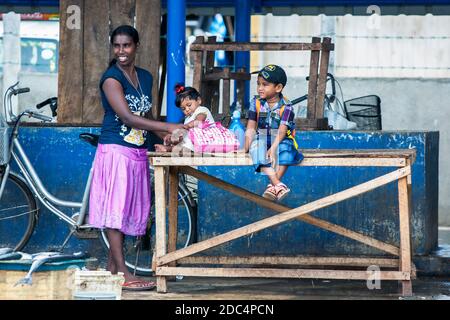A lady stands with her children at the Negombo Fish Market on the west coast of Sri Lanka. Stock Photo