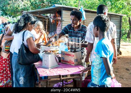 A fruit seller weighs fresh grapes on a scale for a customer at a market near Jaffna in northern Sri Lanka. Stock Photo