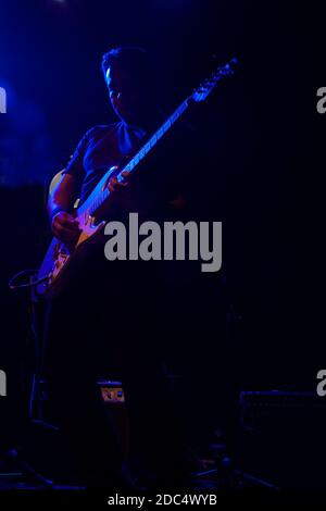 Silhouette of Mexican guitarist playing guitar in concert with blue and pink light Stock Photo