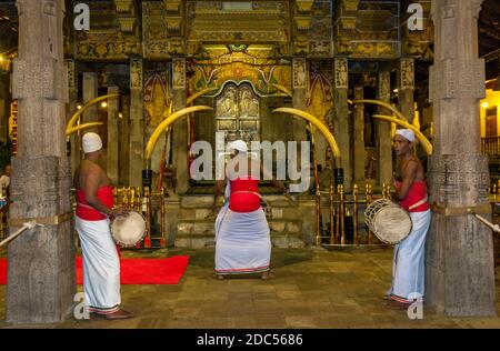 A Buddhist ceremony with Sri Lankan drummers taking place in front of the Patamalaya within the Temple of the Sacred Tooth Relic at Kandy in Sri Lanka Stock Photo