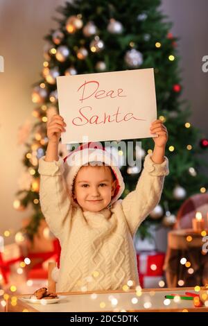 Cute little boy with letter to Santa at home on Christmas eve Stock Photo