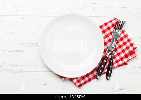 White empty plate, fork, knife and napkin on wooden table. Top view flat lay with space for your meal Stock Photo