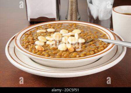 A bowl of lentil soup with saltine crackers Stock Photo