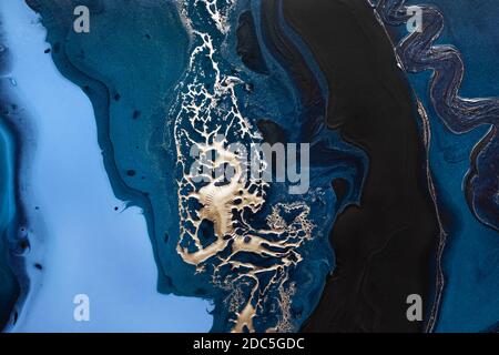 Fluid Art. Liquid Metallic Gold in abstract blue wave. Marble effect background or texture Stock Photo
