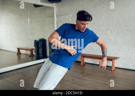 Concentrated man performing an isolation movement while dancing Stock Photo
