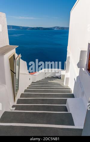 Traditional narrow stairs leading to the sea in Oia Santorini Island, Greece. Stock Photo