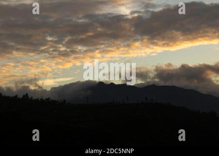 cloudy sky over Mount Sindoro. black clouds with morning sunlight Stock Photo