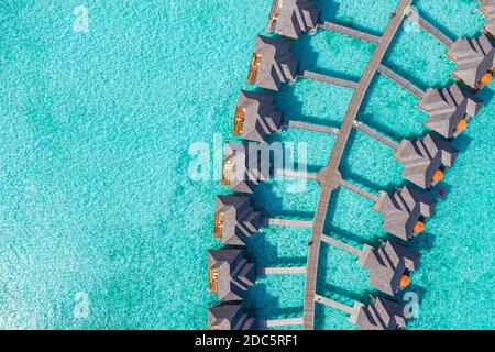 Amazing aerial landscape, Maldives island, luxury water villas resort and wooden pier. Beautiful sky and clouds and beach, summer vacation holiday