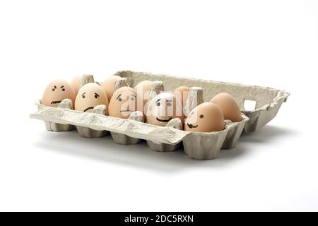 A closeup shot of smiley eggs in the pack on a white background Stock Photo