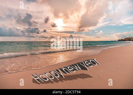 Happy new year written in the sky. Artistic summer beach holiday with new years eve concept Stock Photo