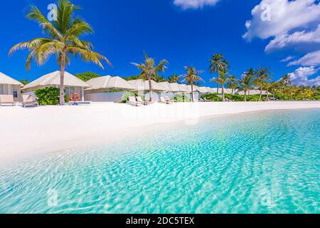 Beach villas on tropical island beach, exotic travel lancdspe, summer vacation. Perfect ocean lagoon, exotic sea. Luxury resort apartment, bungalows Stock Photo