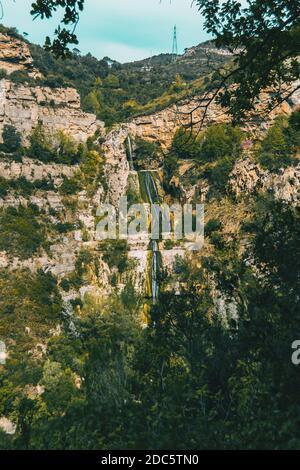 Landscape wit views of a waterfall flowing through the slope of a steep mountain in the wild Stock Photo