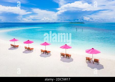 Aerial view of umbrellas, lagoon with sandy beach of Indian Ocean at summer holiday. Tropical landscape with sunny tropical coast shore. Amazing beach Stock Photo