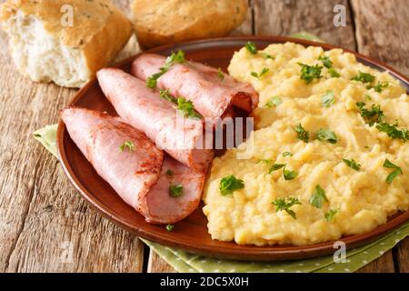 English pea pudding with fried ham served with bread close-up in a plate on the table. horizontal Stock Photo