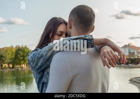 Serene, affectionate young couple hugging at lakeside Stock Photo