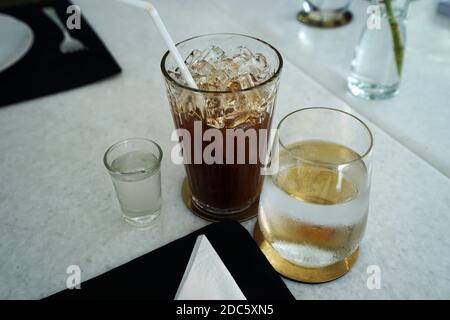 Close up glass of iced black Americano coffee with spring water and sugar syrup Stock Photo