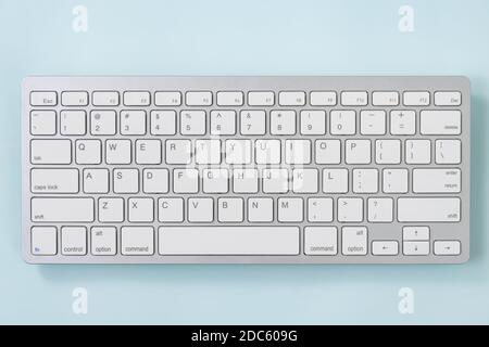 Close up White Portable Computer Keyboard Keys or Keyboard Button on Blue Pastel Minimalist Background at Center Frame Stock Photo