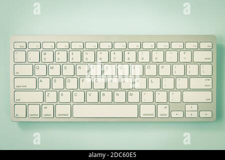 Close up White Portable Computer Keyboard Keys or Keyboard Button on Blue Pastel Minimalist Background at Center Frame in Vintage Tone Stock Photo