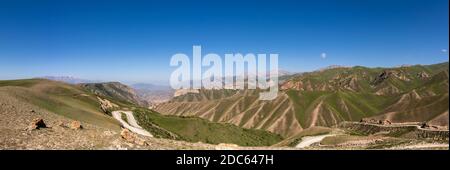 Panorama of the Toguz Toro Pass with road in Kyrgyzstan on a summers day with blue sky and mountains. Stock Photo