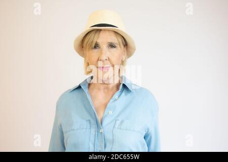 Image of senior woman with short blond hair wearing straw summer hat Stock Photo