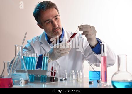 Researcher in laboratory looking at a sample in a test tube. Horizontal composition. Front view. Stock Photo