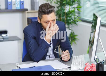 tired businessman with eyeglasses in office Stock Photo