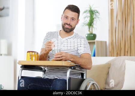 man in wheelchair having breakfast Stock Photo