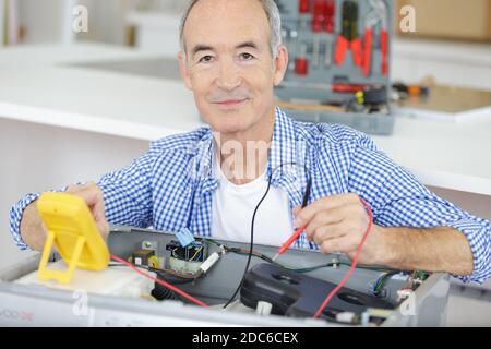 senior electrician working safely on switches Stock Photo