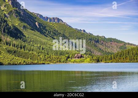 Morskie Oko mountain lake, surrounding forest, Miedziane and Opalony Wierch peaks with Schronisko przy Morskim Oku shelter house in background in Tatr