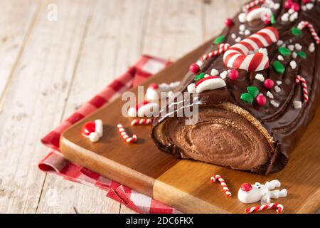 Chocolate yule log christmas cake on wooden table Stock Photo