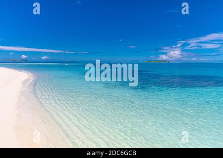 Tranquil beach scene. Exotic tropical beach landscape. Design of summer vacation holiday concept, waves, sea horizon over white sand with blue sky. Stock Photo