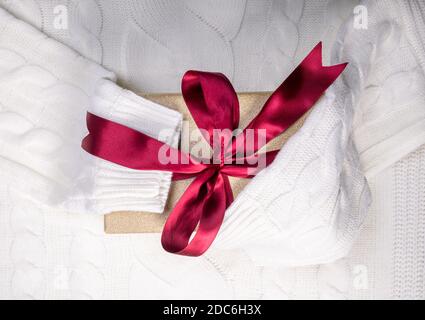 beautiful gift box with red bow knot on white sweater Stock Photo