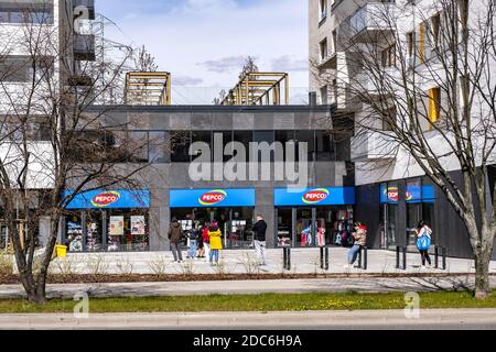 Warsaw, Mazovia / Poland - 2020/04/18: Customers queuing for sanitary products as per COVID-19 social distancing restrictions in Ursynow residential d Stock Photo