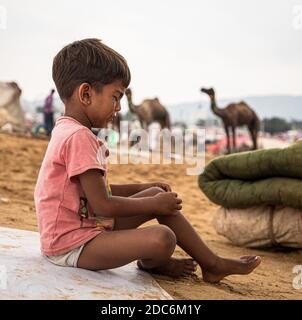 a little rajasthani boy is crying at pushkar camel festival. Stock Photo