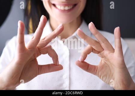 Businesswoman holds her finger in gesture of ok. Stock Photo