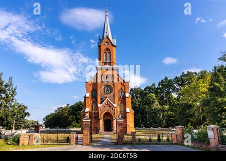 Naglowice, Swietokrzyskie / Poland - 2020/08/16: Neo-gothic parish church of St. Mary Rosary near park and historic museum manor house of Mikolaj Rej, Stock Photo