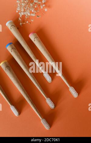 Set of wooden bamboo toothbrushes on orange background. Stock Photo