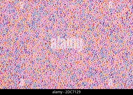 Pastel color balls texture. Styrofoam or Polystyrene foam background. Mix of colorful sugar balls, used to decorate baking and sweets. Rainbow colored Stock Photo