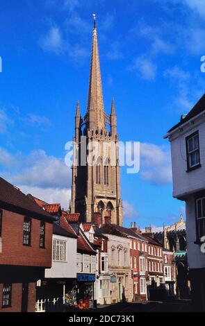 The tall spire of the Church of St. James behind the main street and shops. Louth. Lincolnshire. England. UK. Europe Stock Photo