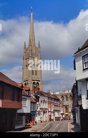 The tall spire of the Church of St. James behind the main street and shops. Louth. Lincolnshire. England. UK. Europe Stock Photo