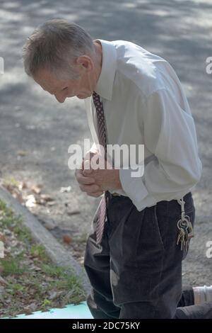 A devout Christian man prays at the Vatican Pavilion site in Flushing Meadows park where Mary & Jesus appeared to Veronica Lueken. In Queens NYC. Stock Photo