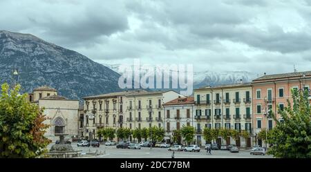 SULMONA, ITALY - september 27 2020: cityscape with people strolling in Garibaldi square while snowy Maiella peak  looms in background, shot in bright Stock Photo