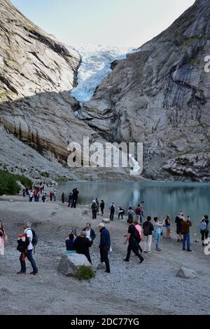 The Briksdal glacier is one of the most accessible arms of the Jostedalsbreen glacier in Norway. Sightseers are seen alongside the glacial lake. Stock Photo