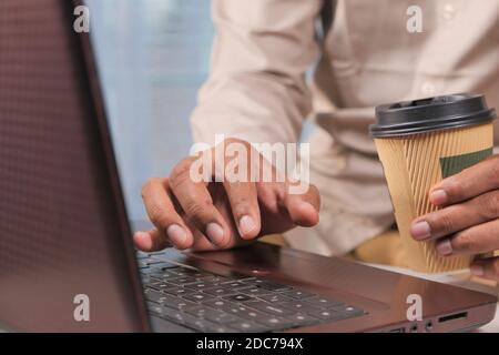 young man using laptop and drinking coffee  Stock Photo