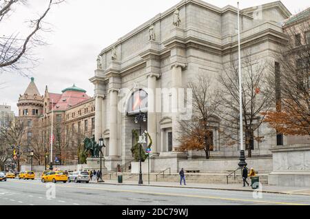 Facade And Entrance of American Museum of Natural History in Manhattan. A Yellow Taxis Waiting Passing Outside the Building. New York City, USA Stock Photo